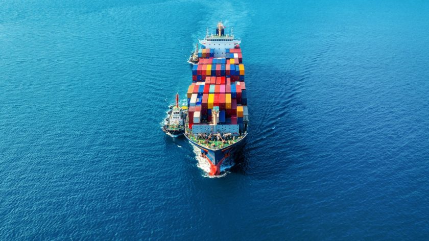 Aerial view of cargo ship with cargo container on sea.